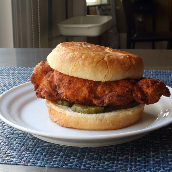 a fried chicken breast on a burger bun with pickle slices
