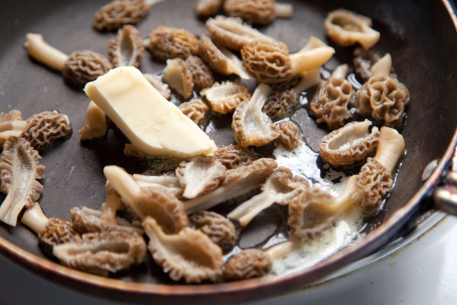 Morel mushrooms being sautéed with butter