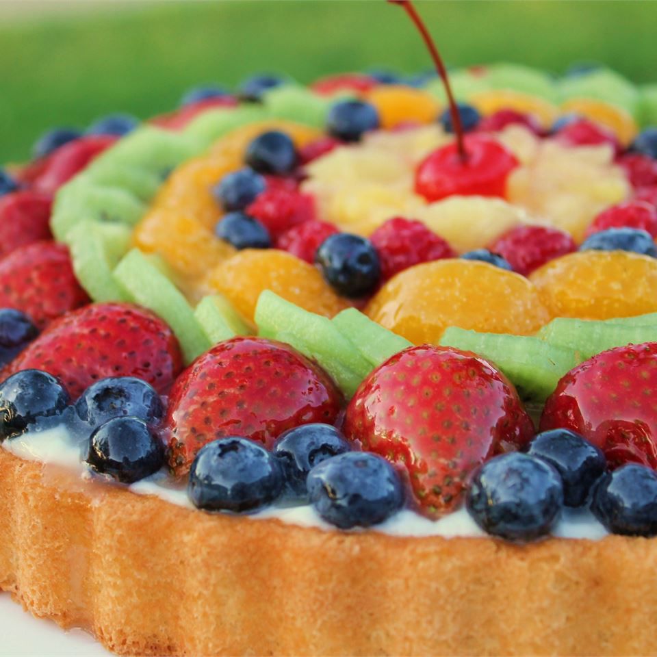 sponge cake topped with blueberries, strawberries, kiwi, oranges