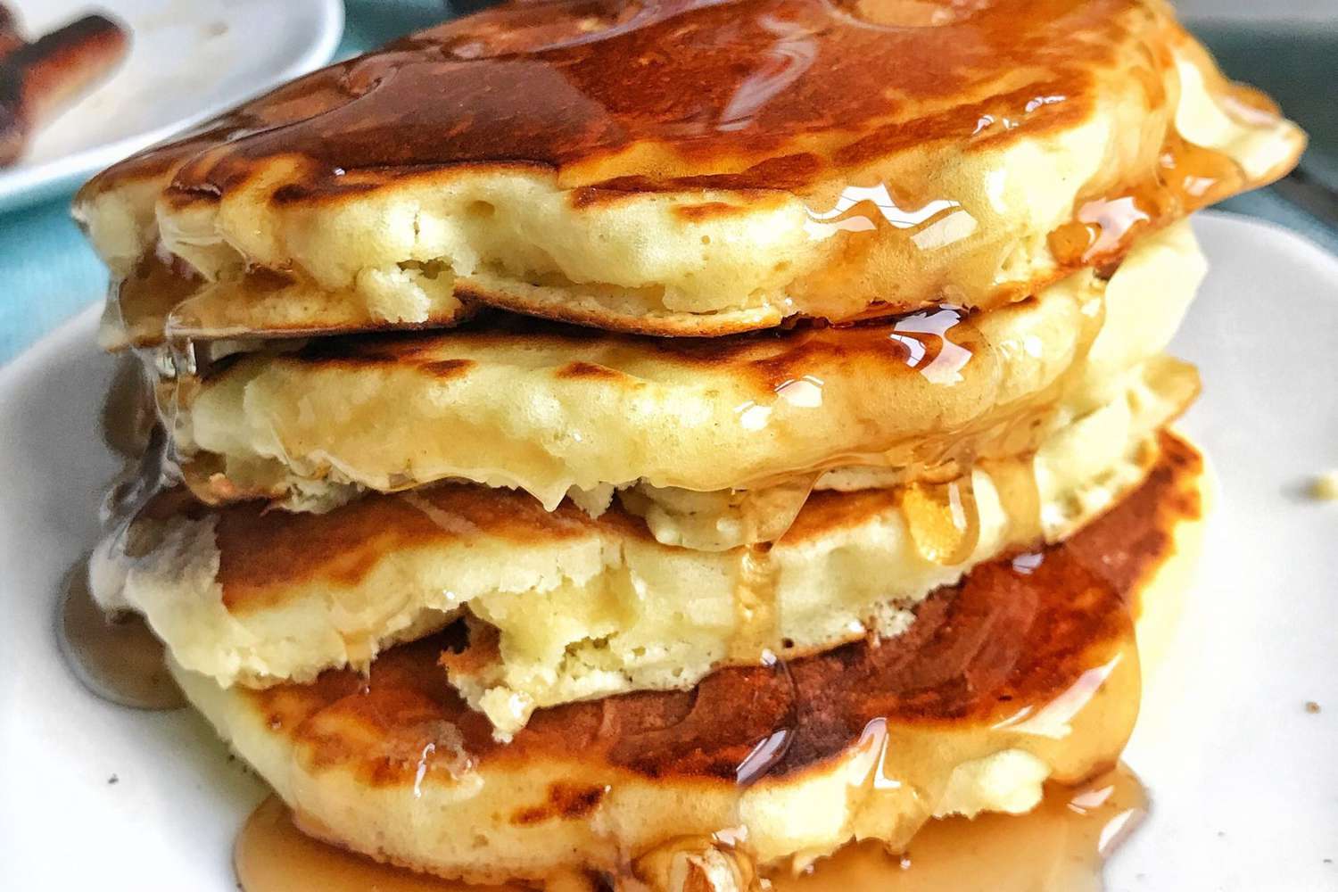 Good old fashioned pancakes stacked with syrup drizzled on top