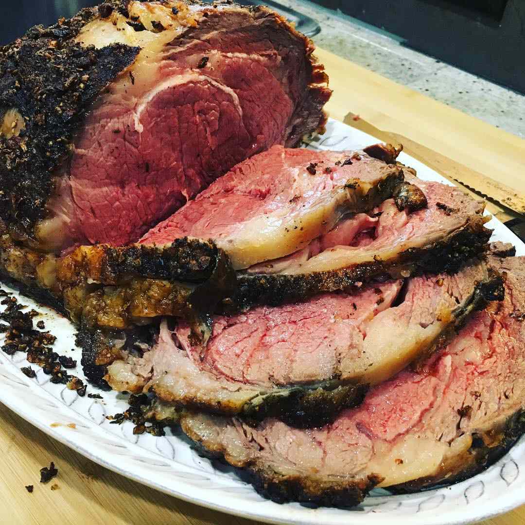 medium-rare prime rib on a platter with thick slices ready for serving
