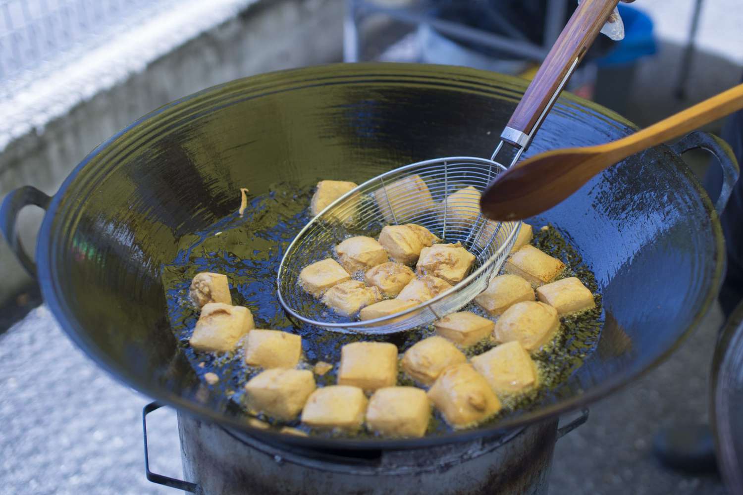 Cooking frying tofu in pan with soybeanoil