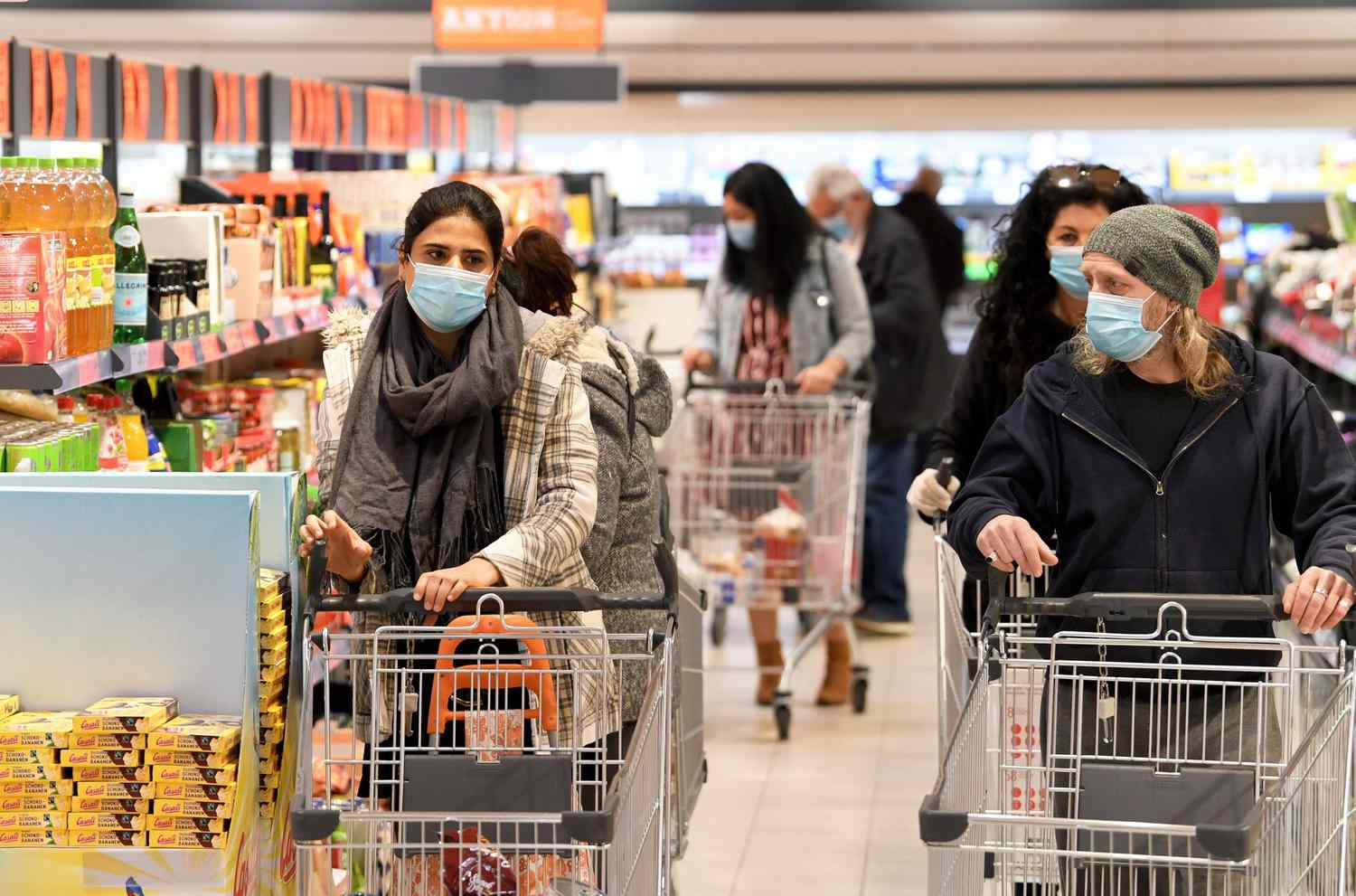 Customers wear face protection in a supermarket in Vienna on April 6, 2020. - As of today, April 6, 2020, it is mandatory in Austria to wear such protection in supermarkets with a sales area of 400 m2 or more. (Photo by ROLAND SCHLAGER / APA / AFP) / Austria OUT (Photo by ROLAND SCHLAGER/APA/AFP via Getty Images)