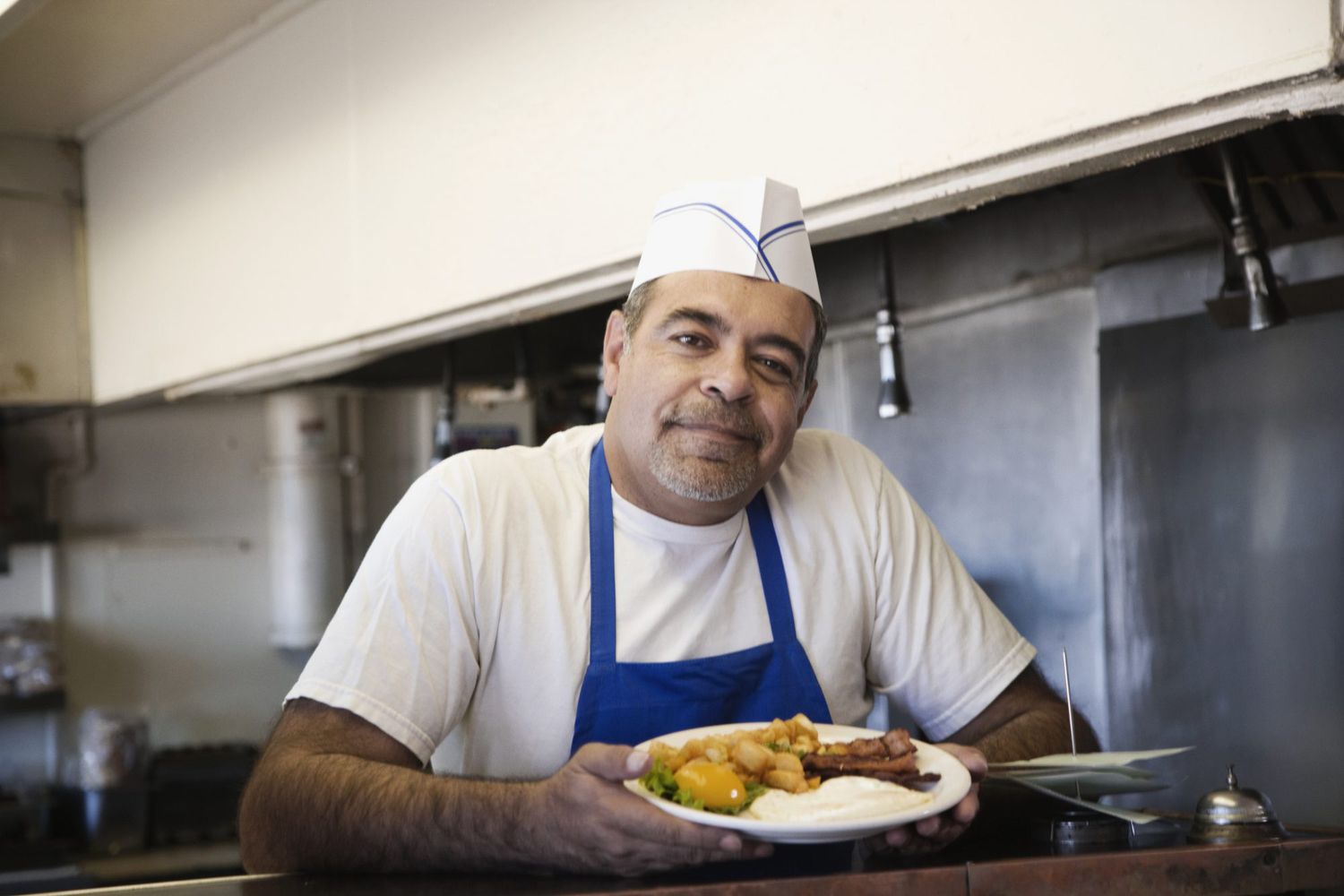 Hispanic male cook holding food