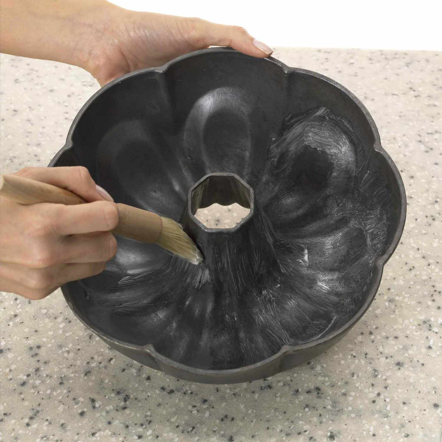 Person greasing bundt pan