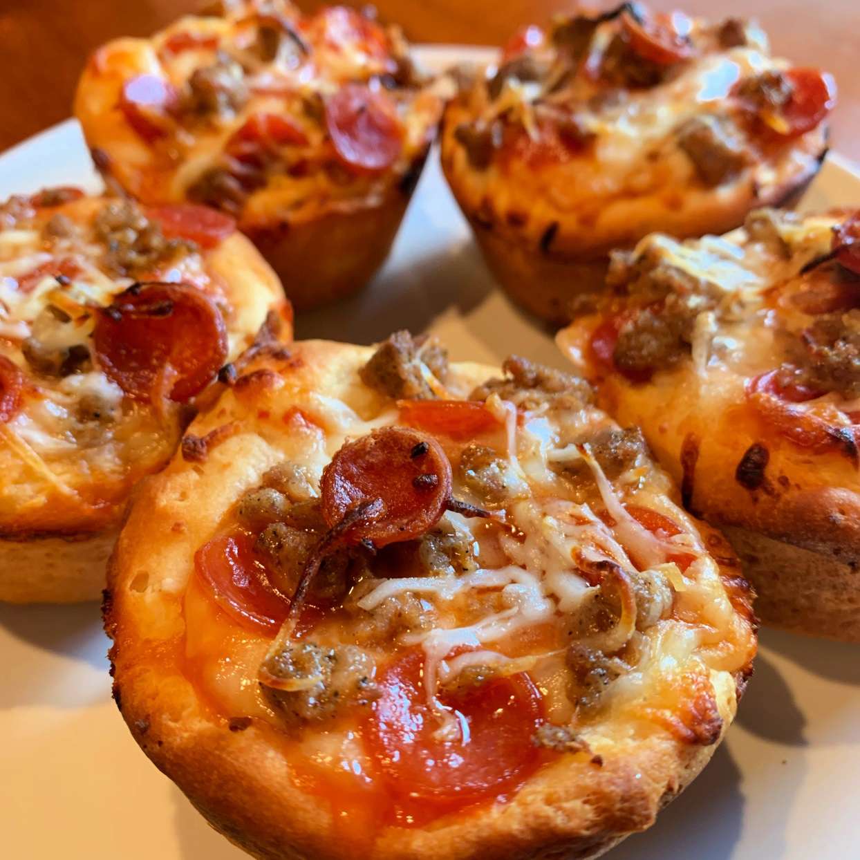 closeup of mini muffin tin pizzas on a plate