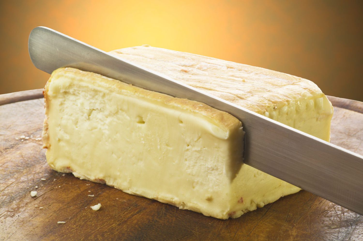 Taleggio cheese on cutting board sliced
