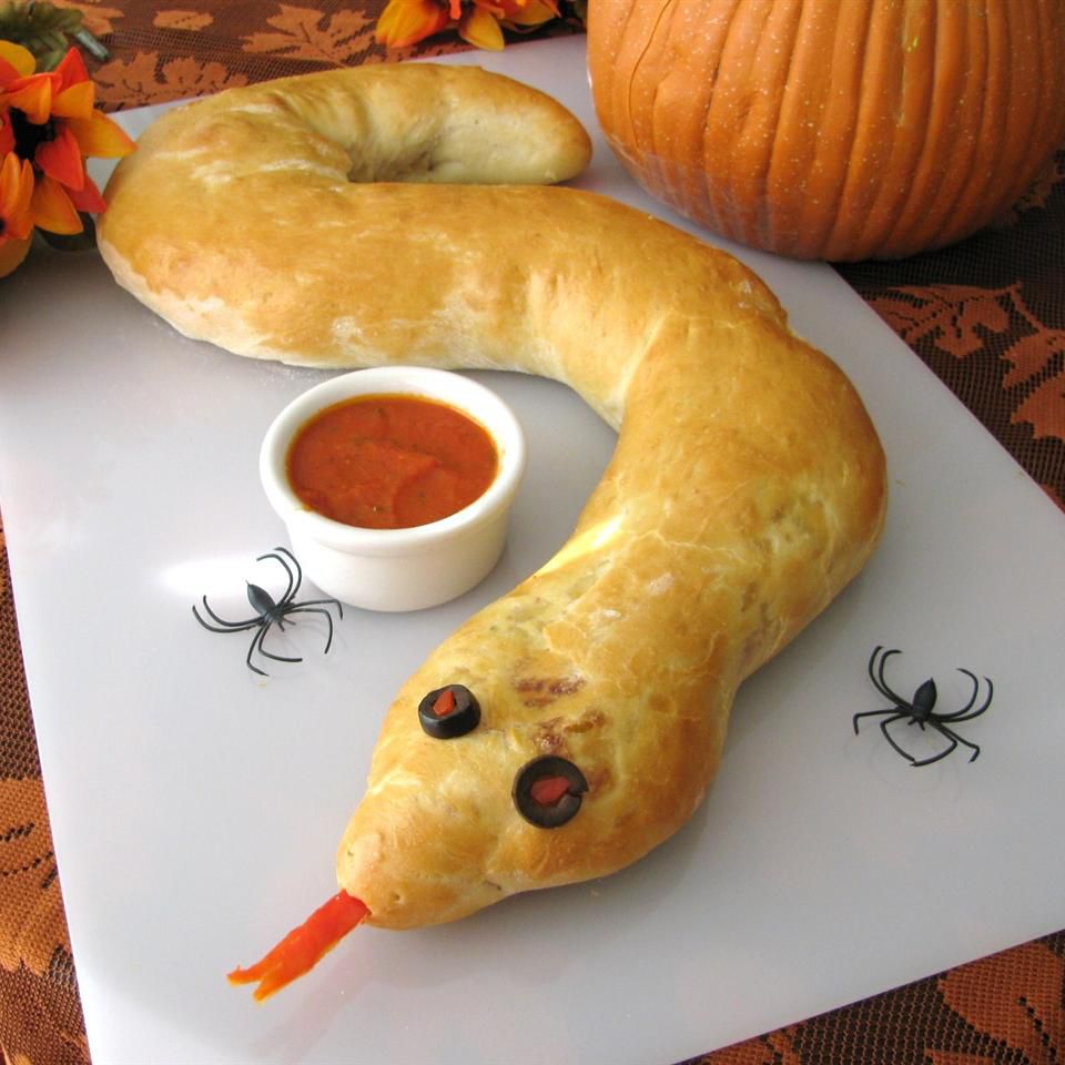 Spooky Calzone Snake with red sauce on a serving platter