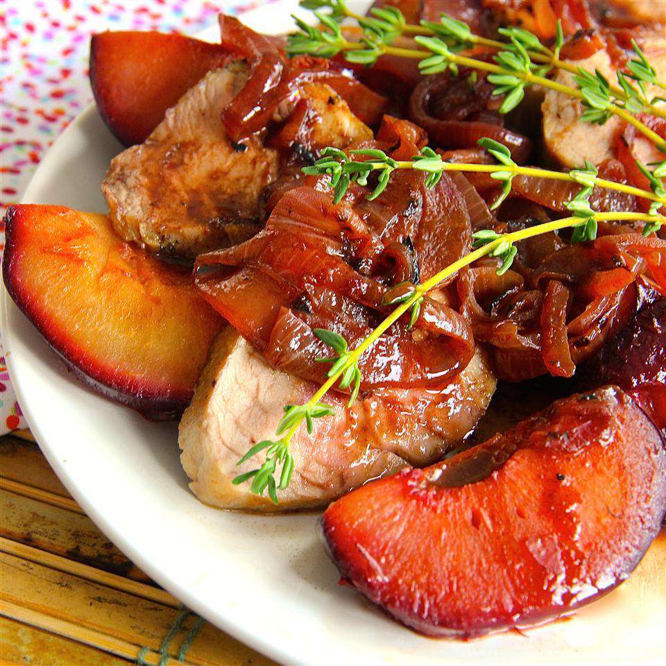 Roasted pork tenderloin with fresh plum sauce served on a plate.