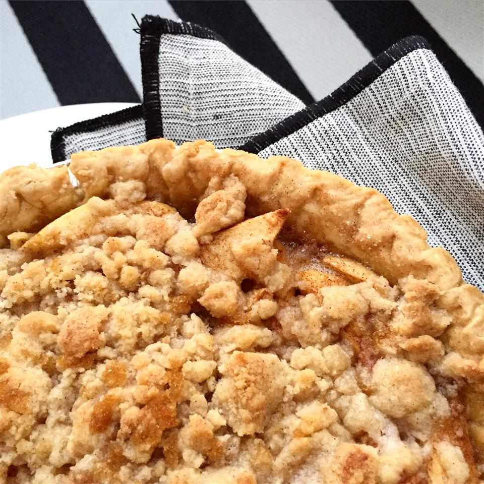 Apple Crumble Pie on a white plate with a grey and black napkin
