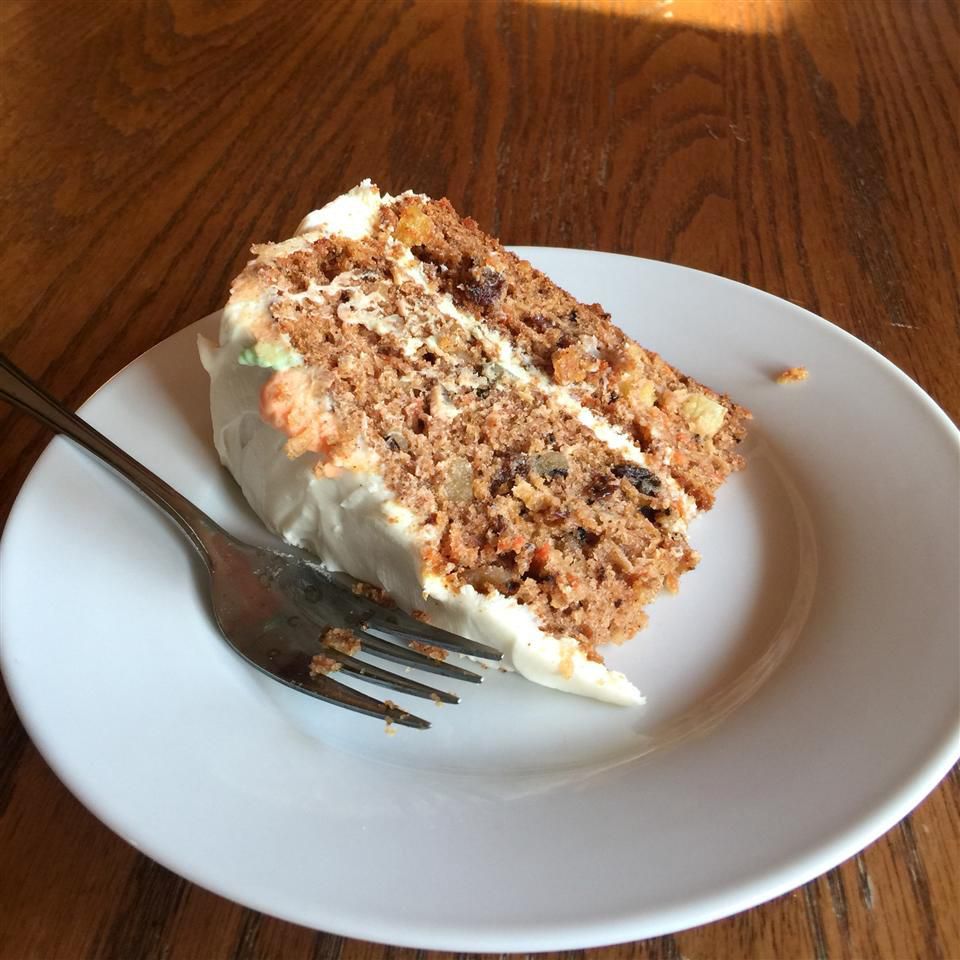 slice of carrot cake on a white plate with a fork