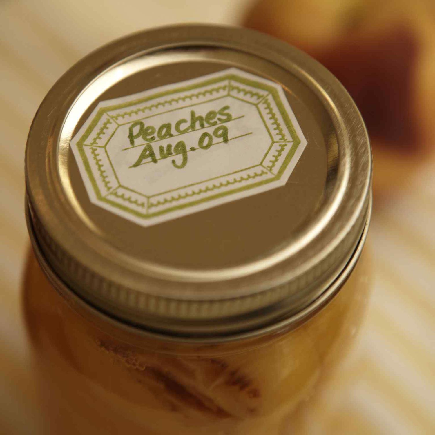 Close up of lid on jar of peaches with label