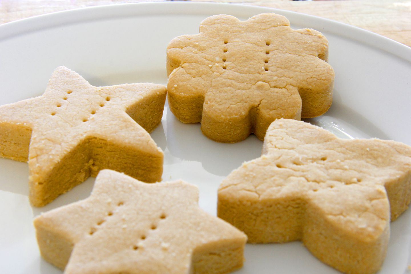 Thick-cut brown sugar shortbread in star and flower shapes on a white plate