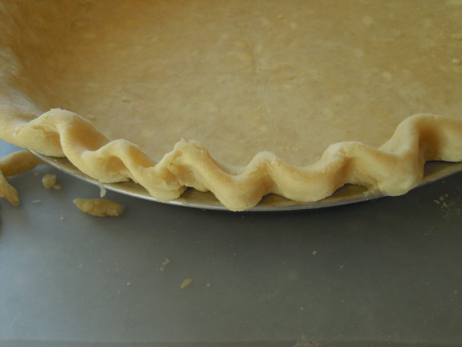 a closeup of the crimped edge of lard-butter pie pastry