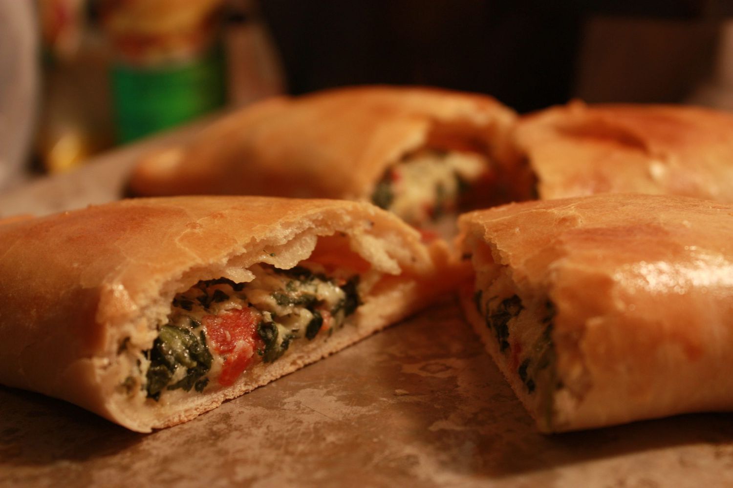 closeup of a calzone cut in half with a ricotta and spinach filling