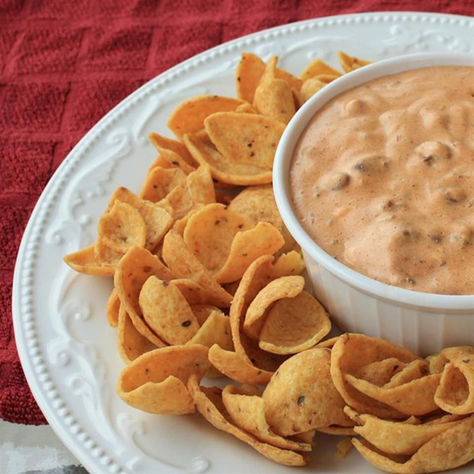 chili dip with fritos on white plate