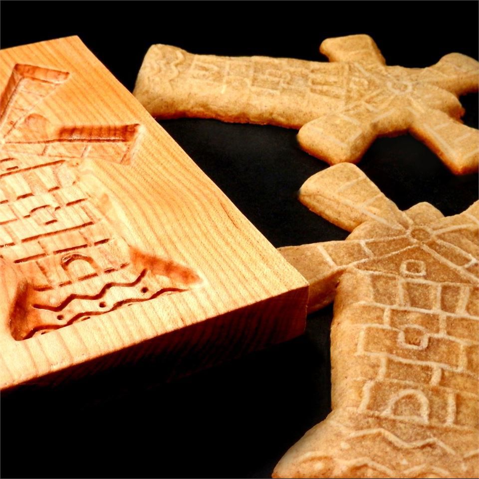 Dutch windmill cookies next to a wooden mold