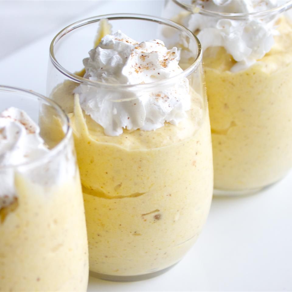 glasses full of pumpkin mousse topped with whipped cream