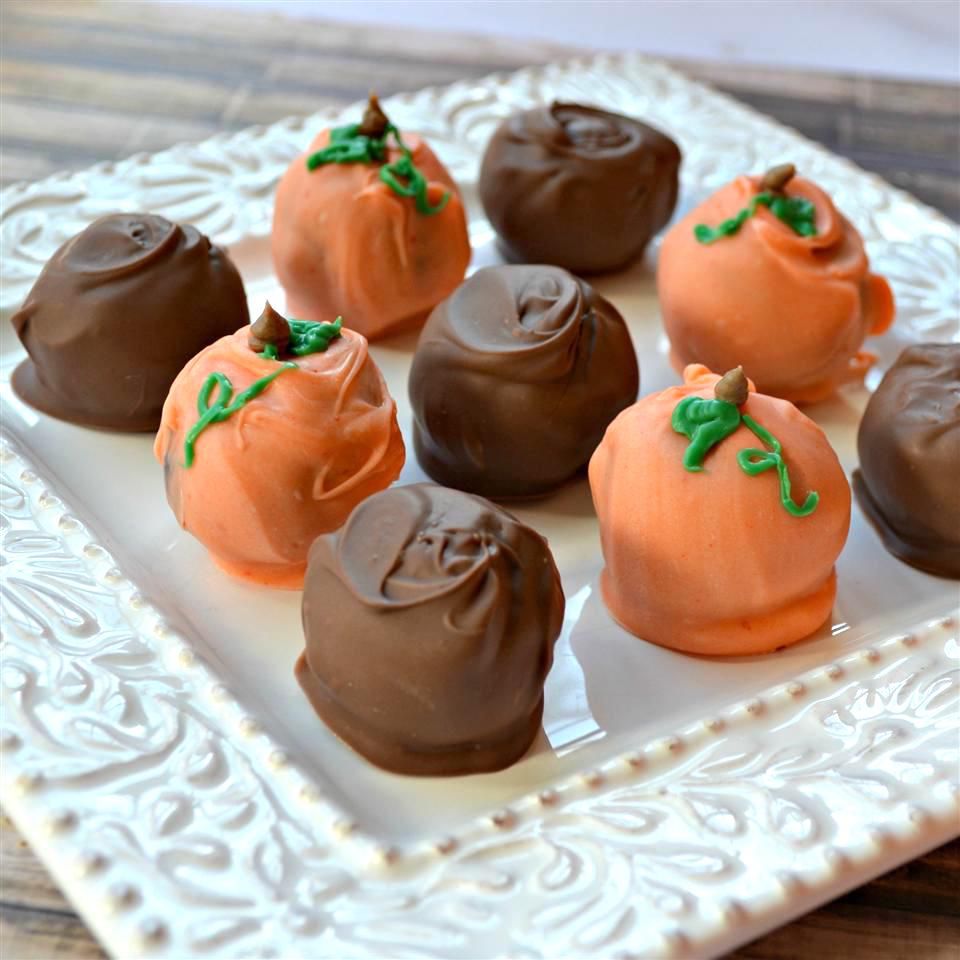 chocolate truffles and orange chocolate pumpkin truffles on a white plate