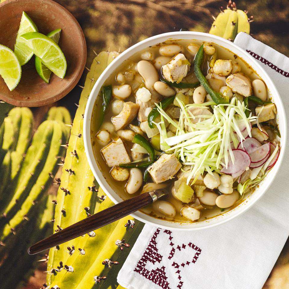 Turkey Posole in a white bowl with limes on the side