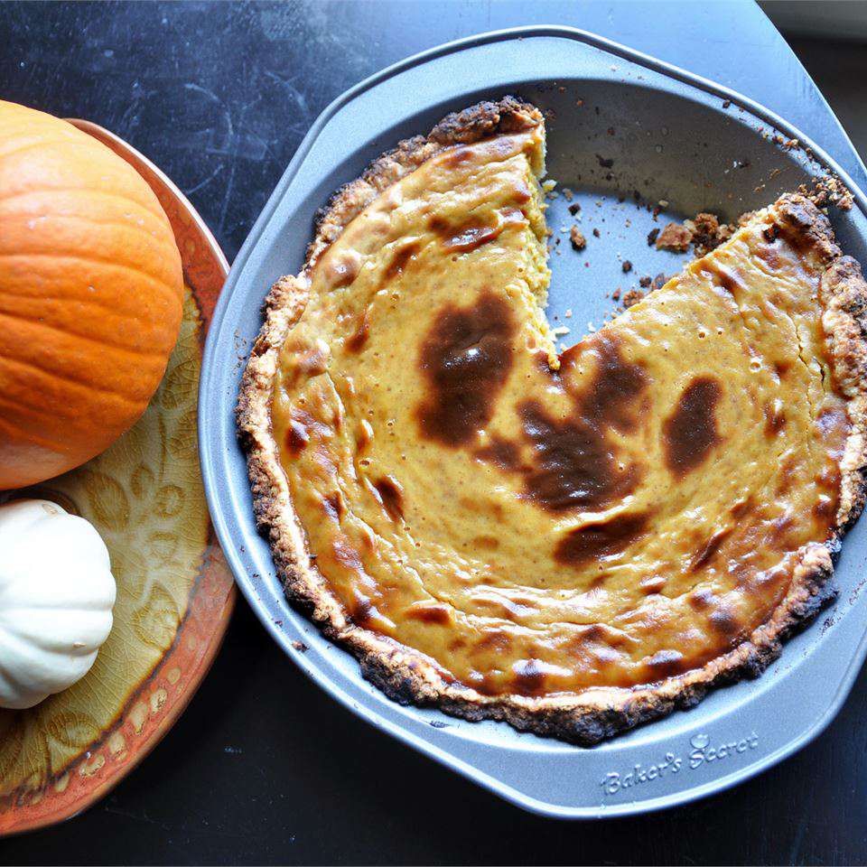 pumpkin pie in a pie dish with a slice cut out