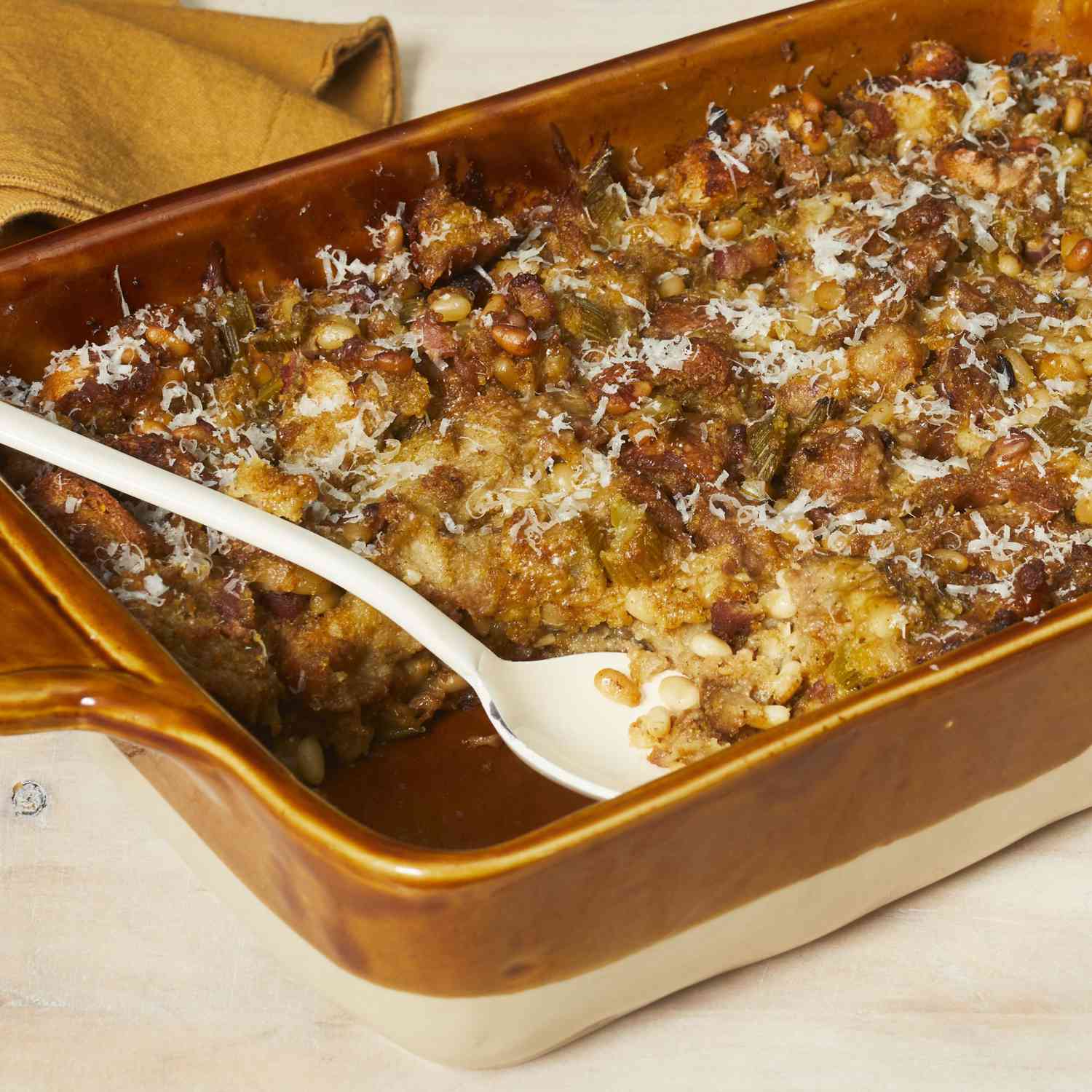 Casserole of Thanksgiving stuffing with a serving spoon.