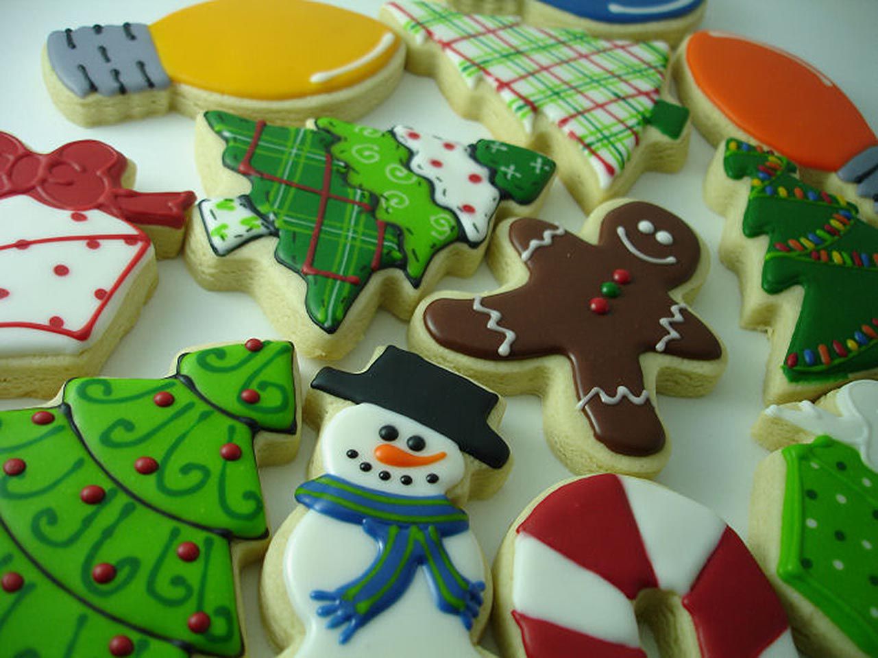 intricately decorated Christmas cookies: snowman, Christmas trees, gingerbread man, candy cane, and colored tree lights