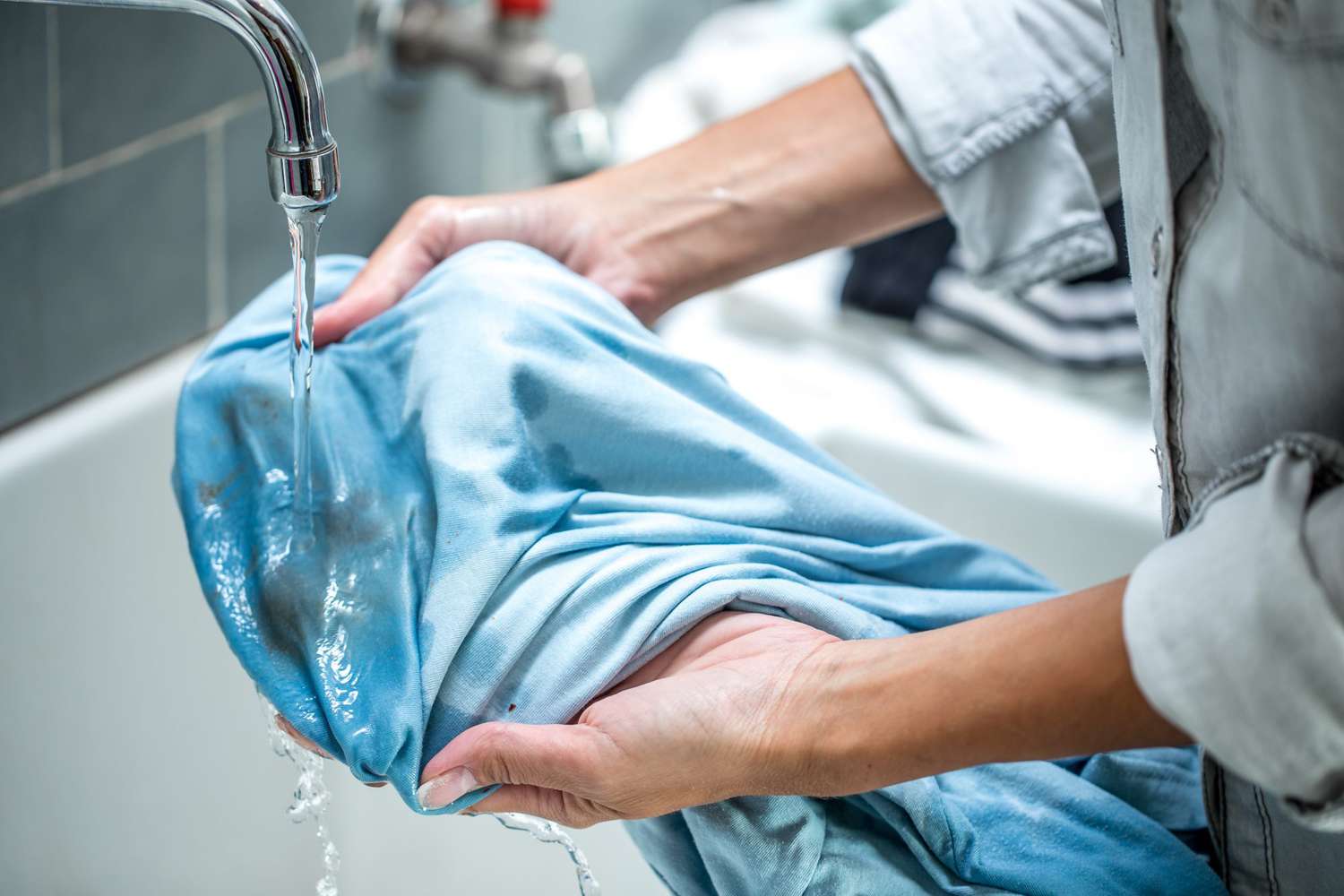 Woman Cleaning Stained Shirt in Bathroom Sink