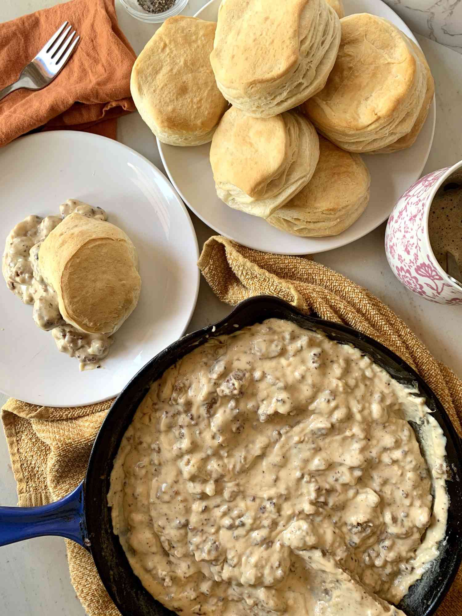 Skillet of Southern-Style Sawmill Sausage Gravy with platters of biscuits.