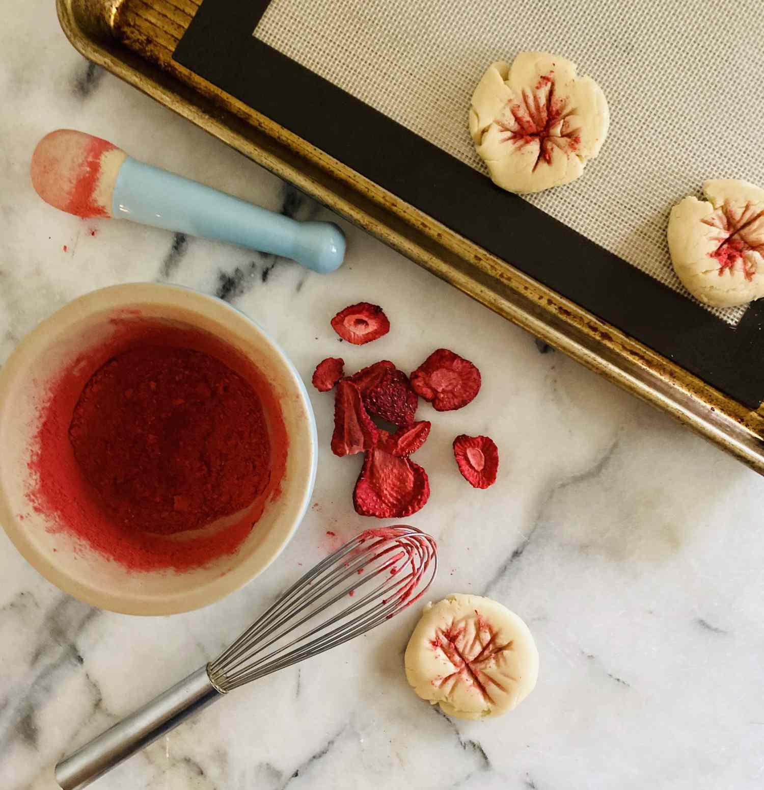 making colored designs in cookie dough with a whisk dipped in freeze-dried strawberries