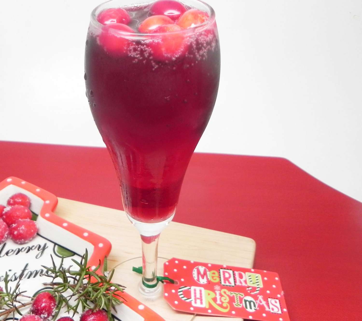 a bubbly ruby red cocktail garnished with fresh cranberries