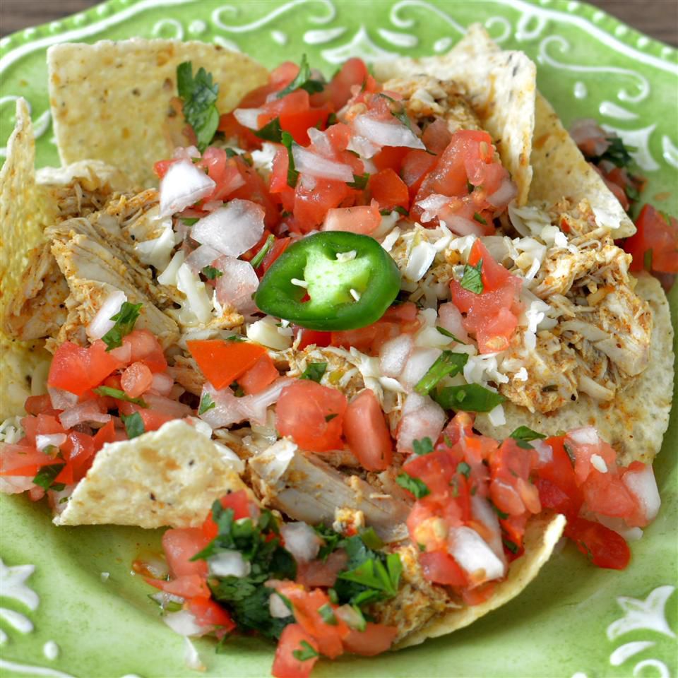 nachos with tomatoes, cilantro, onion, tortilla chips, chicken, and jalapenos