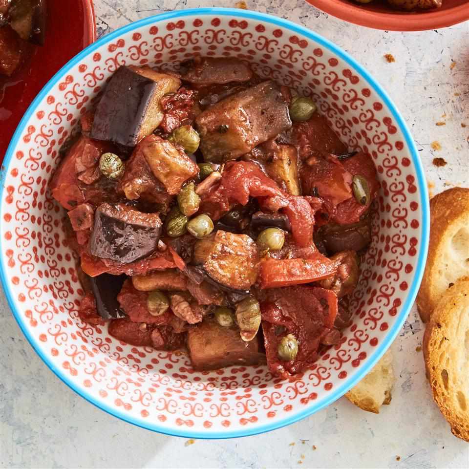 eggplant caponata in a bowl with crusty bread on the side