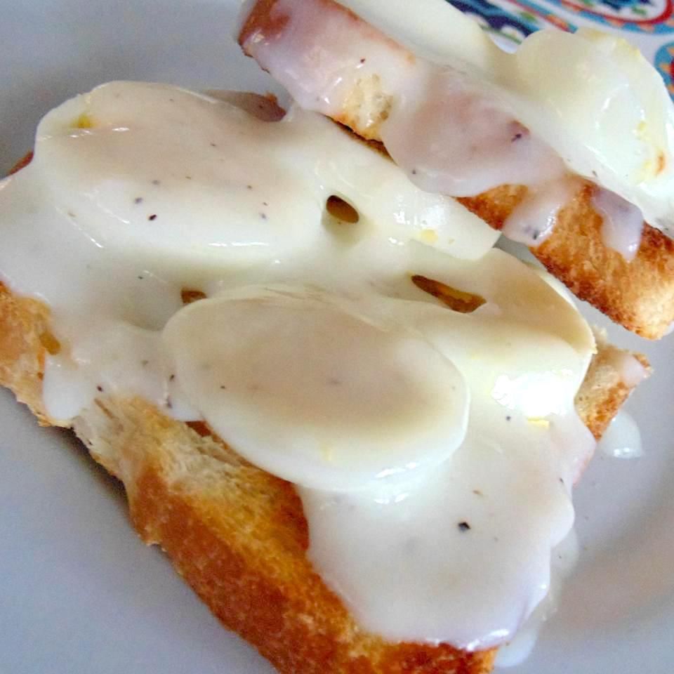 hard boiled eggs on toast with a creamy sauce on top