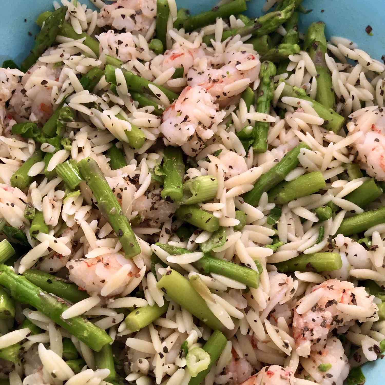 overhead shot of speckled orzo with shrimp and asparagus