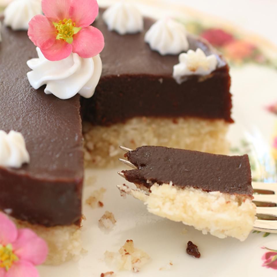 chocolate and coconut layer cake with flower and whipped cream garnish