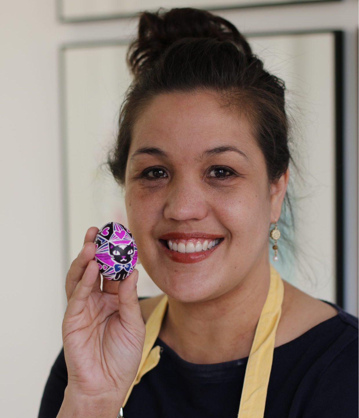 artist holding pysanky egg with kitten design
