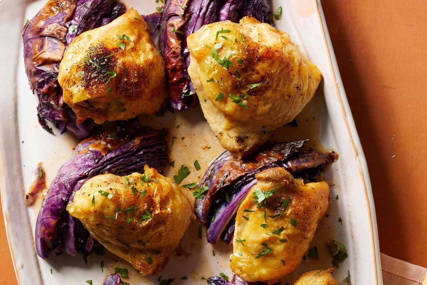 close up of crispy baked chicken thighs served with roasted cabbage