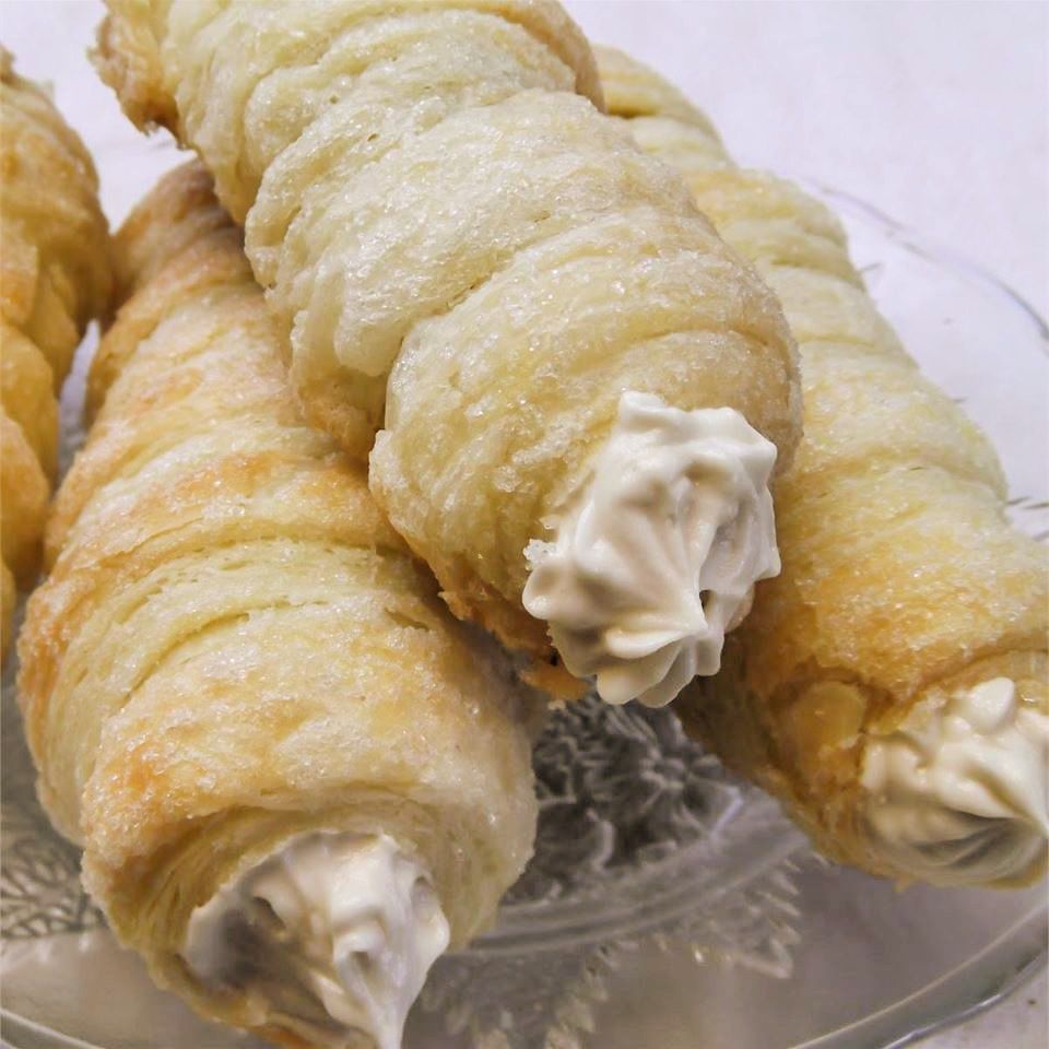 close up of cream horns made of puff pastry and filled with sweetened cream cheese