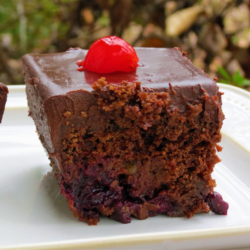 a slice of chocolate cherry walnut beer cake on a white plate