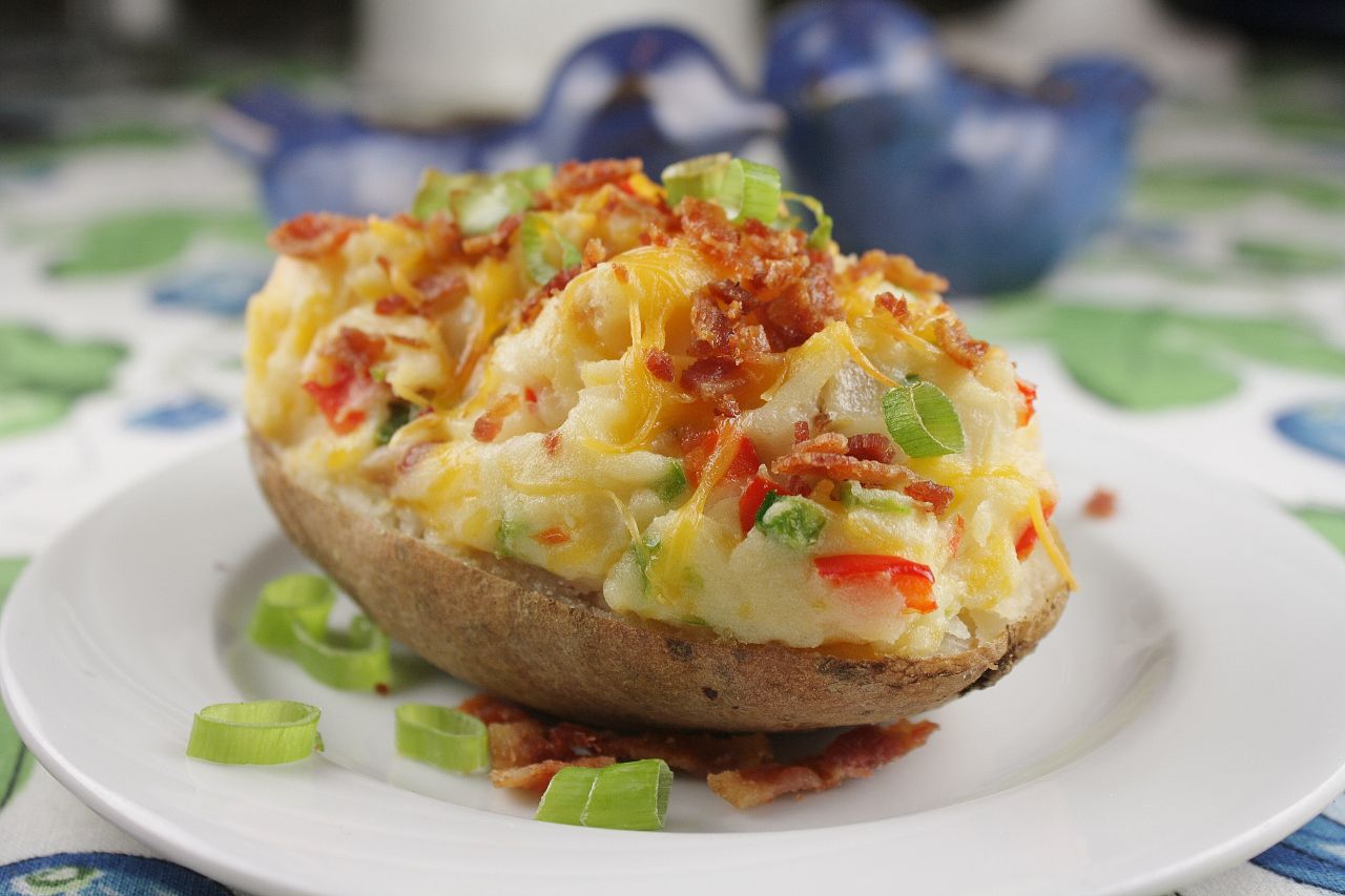 closeup of a loaded baked potato with bacon, Cheddar, and jalapenos
