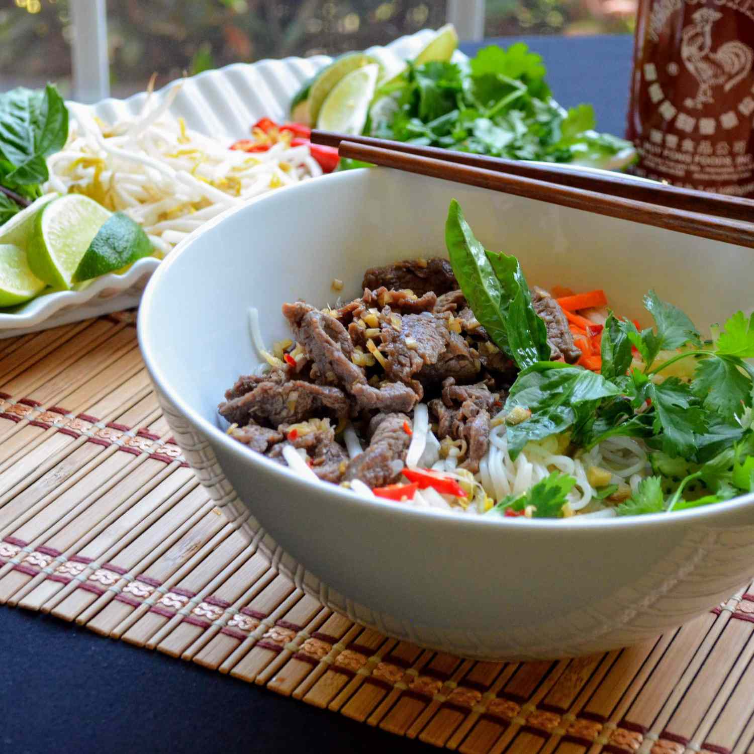 beef, noodles, basil, and pepper in white bowl