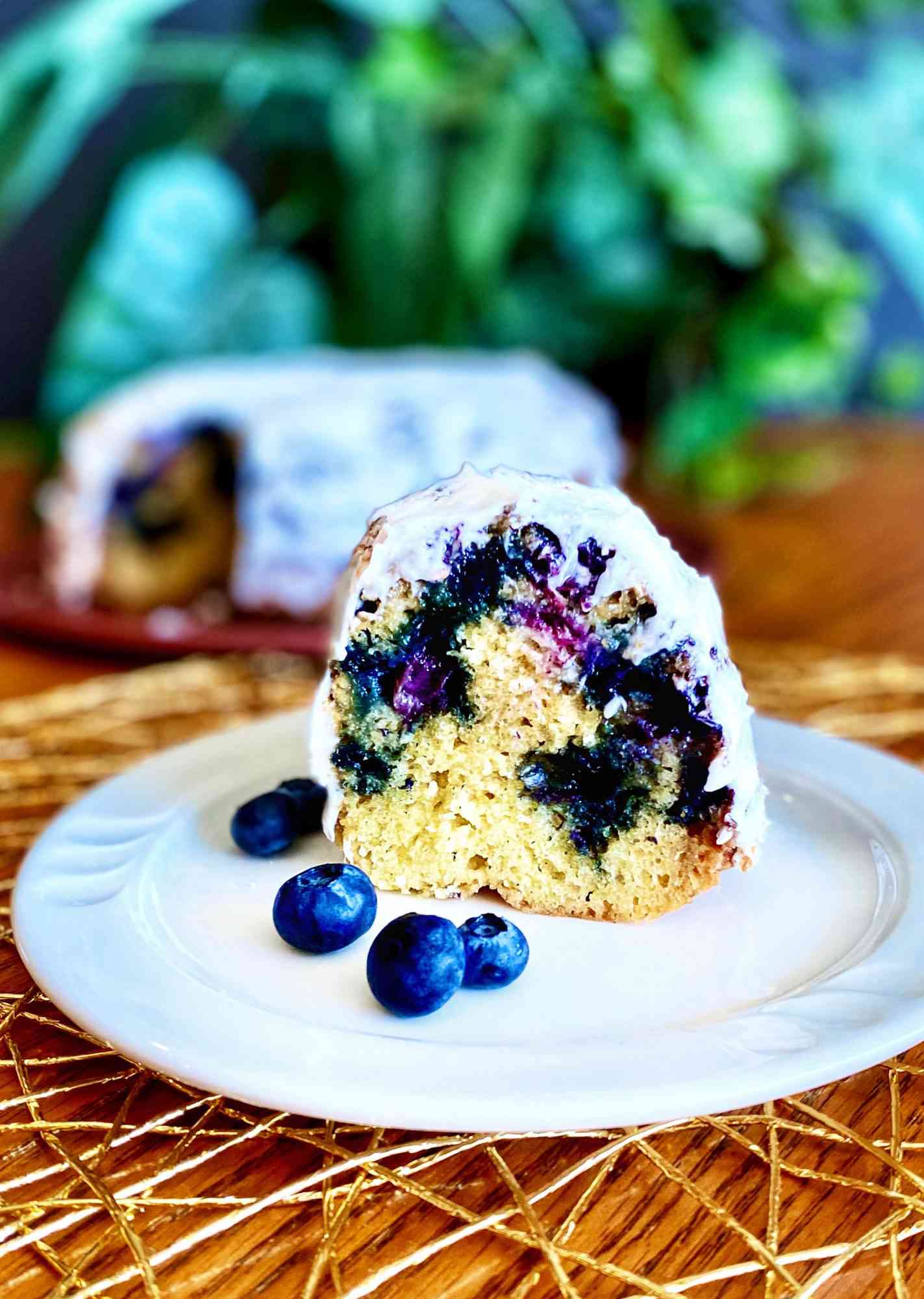 slice of blueberry poundcake with white glaze on white plate