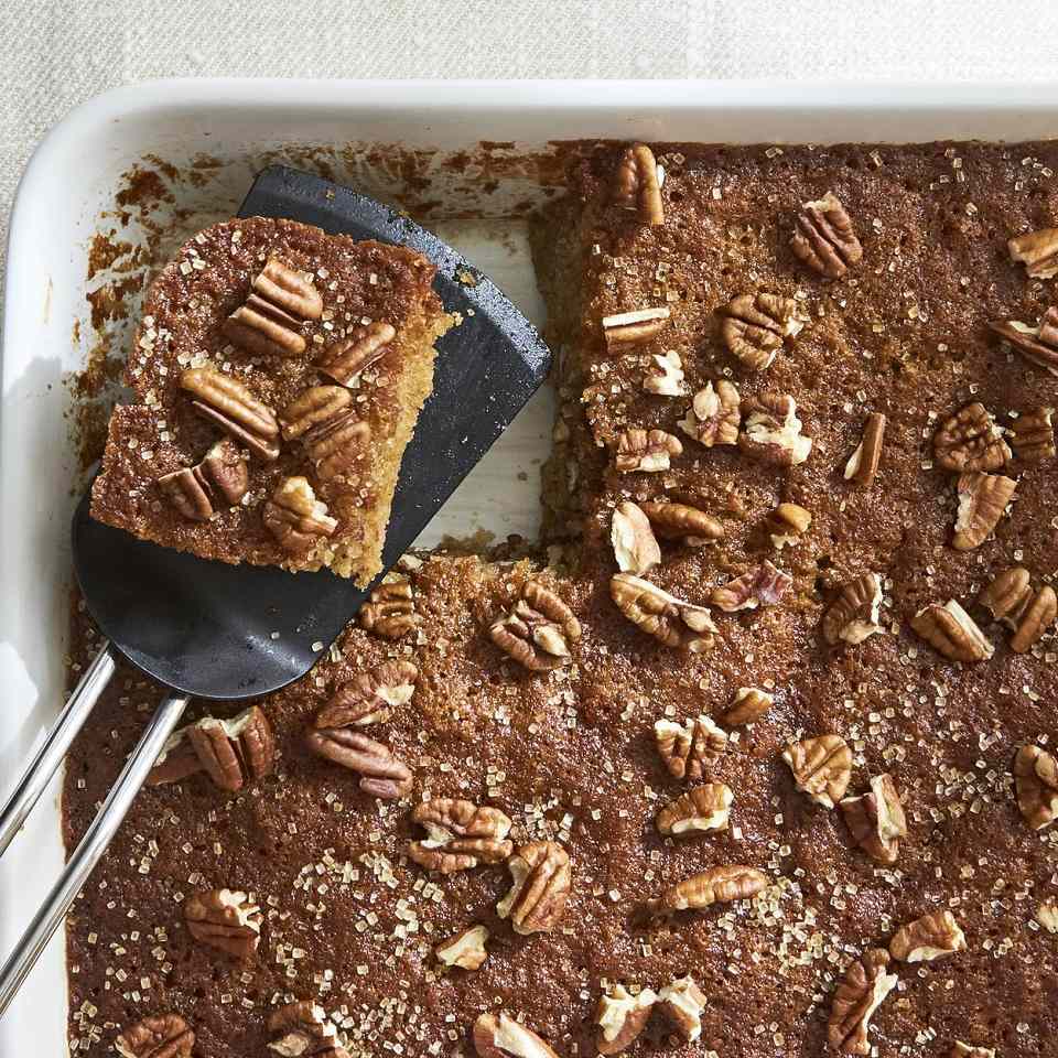 cinnamon cake in a white baking dish with pecans on top