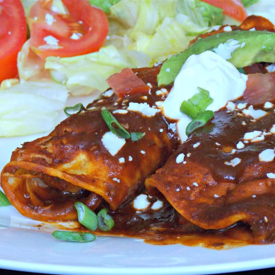a plate of bean and cheese enchiladas