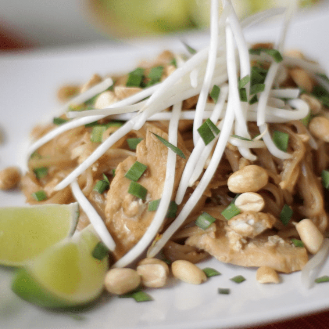a white plate with chicken pad thai