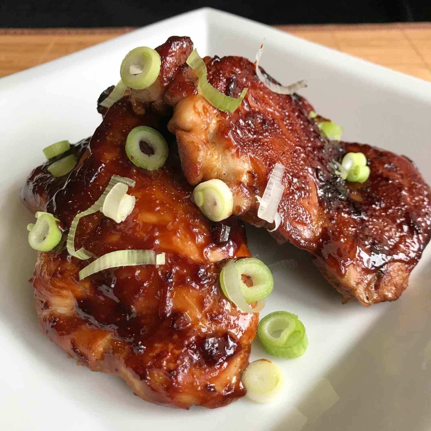 chicken thighs baked with teriyaki sauce and garnished with sliced scallions