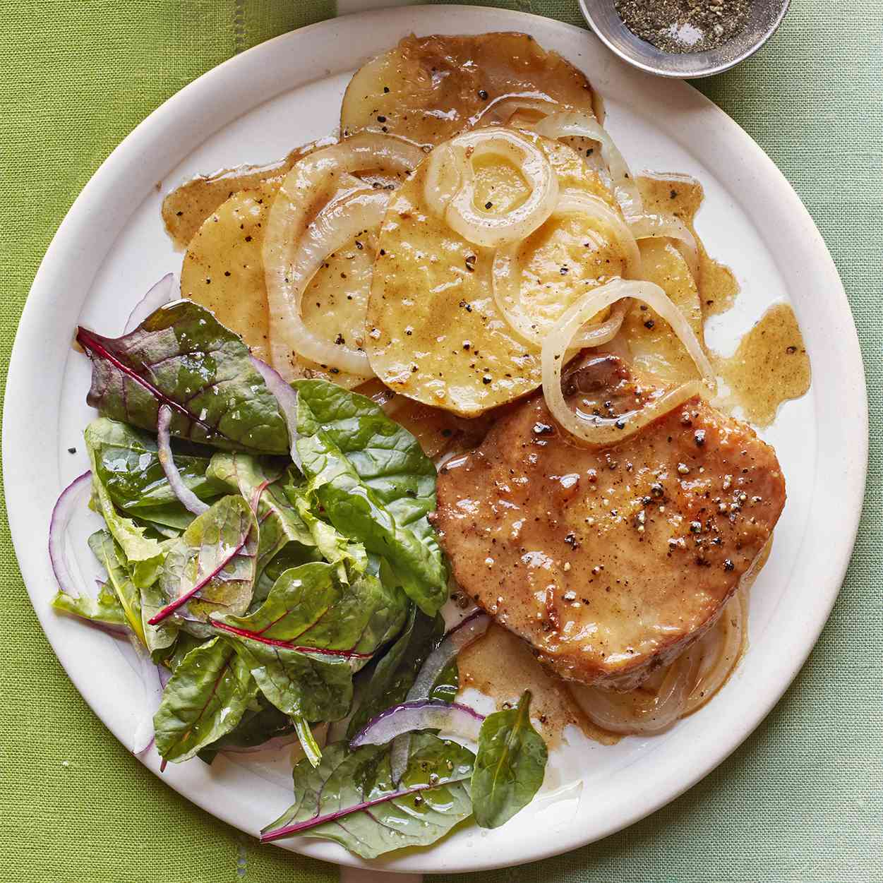 Skillet Pork Chops with Potatoes and Onion recipe on a white plate