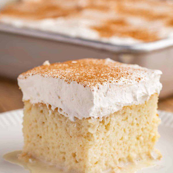 a slice of white cake with creamy-looking frosting
