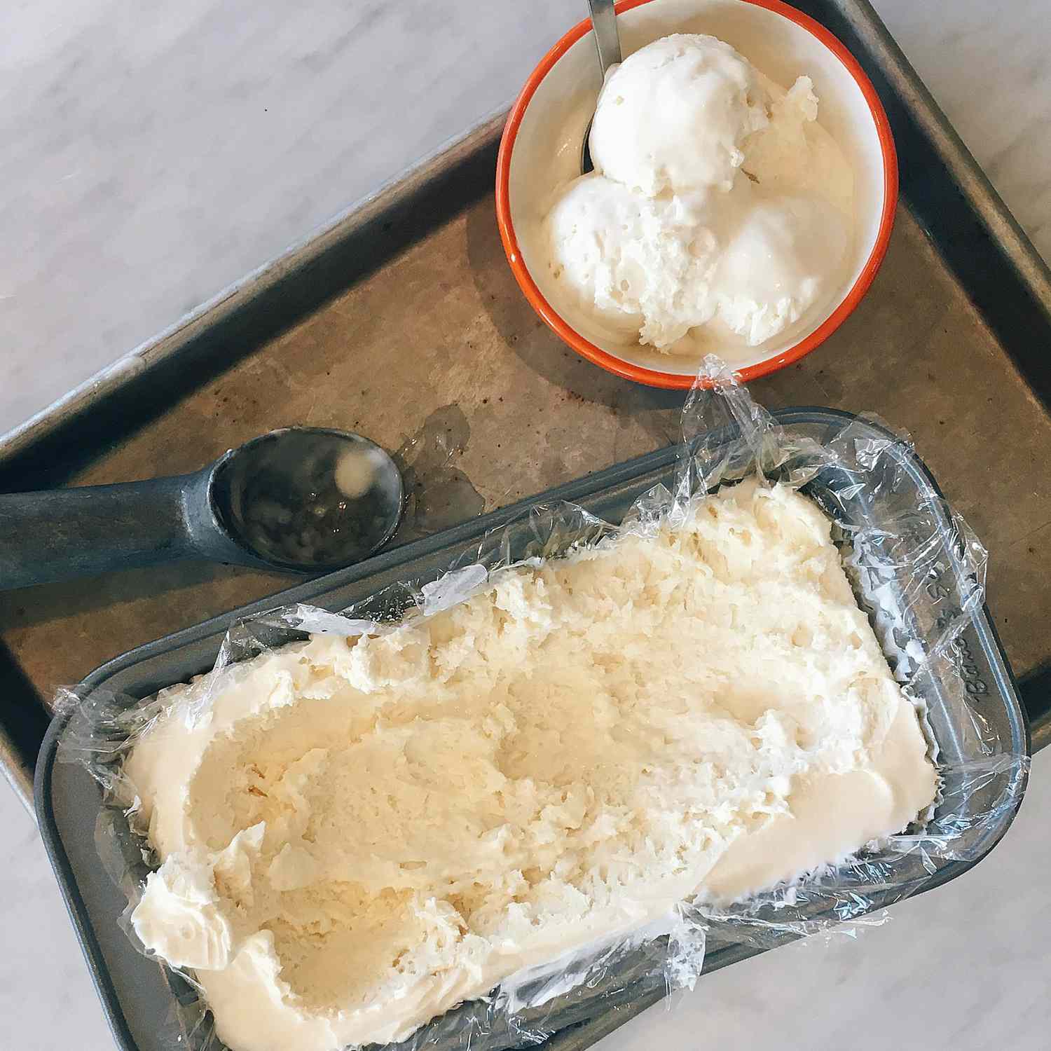 overhead view of homemade No-Churn Vanilla Ice Cream in a loaf pan and in a bowl